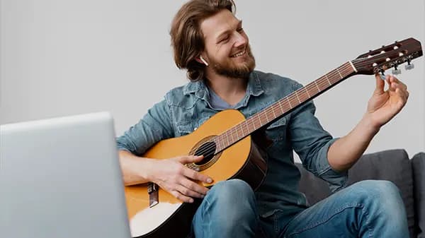 Man taking guitar lessons online