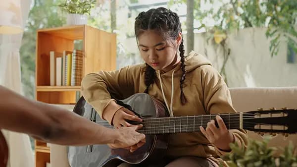 Girl learning to play guitar